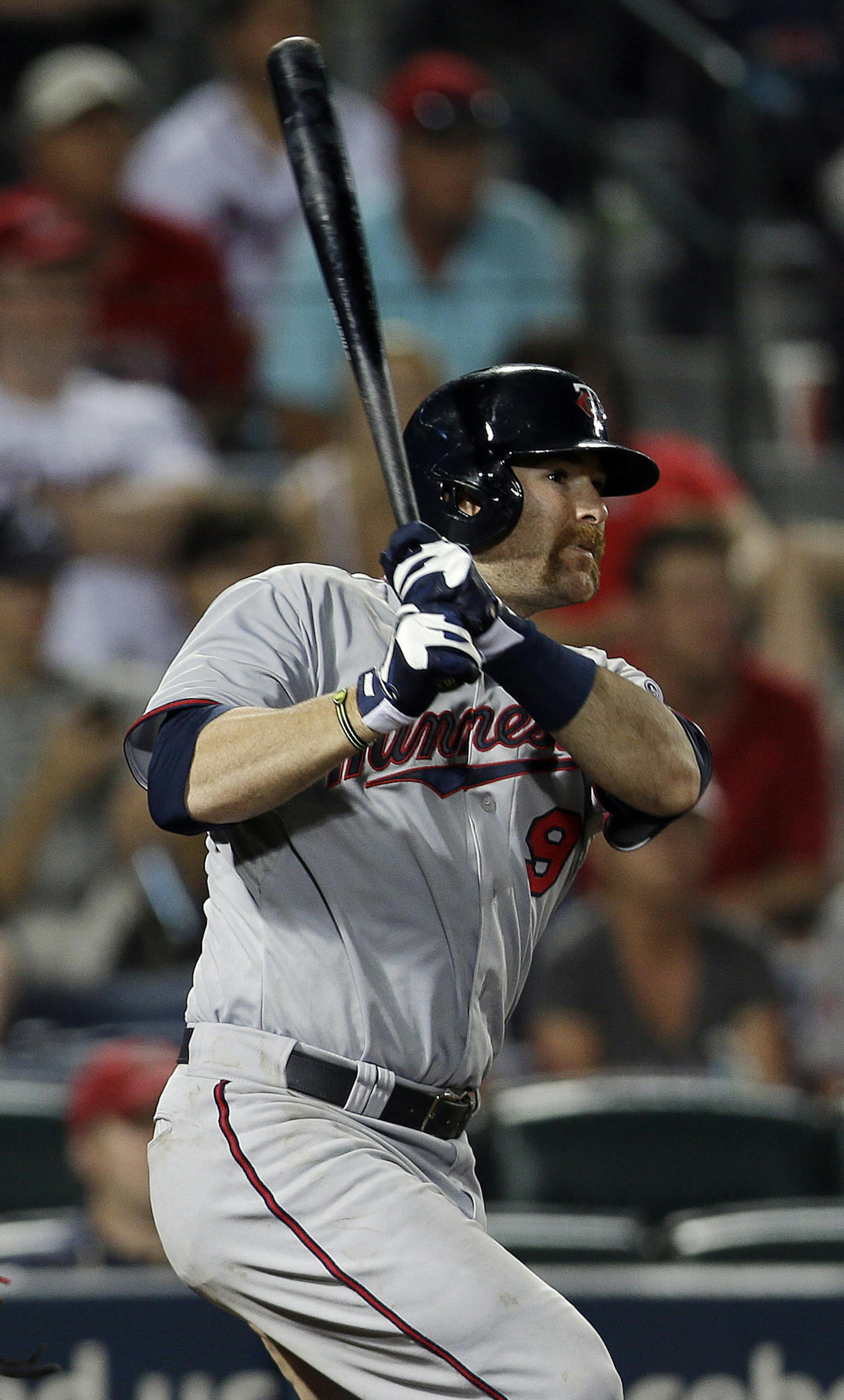 Minnesota Twins designated hitter Ryan Doumit (9) follows through with an RBI base hit as Atlanta Braves catcher Brian McCann (16) watches in the eighth inning of a baseball game Tuesday, May 21, 2013 in Atlanta. (AP Photo/John Bazemore)