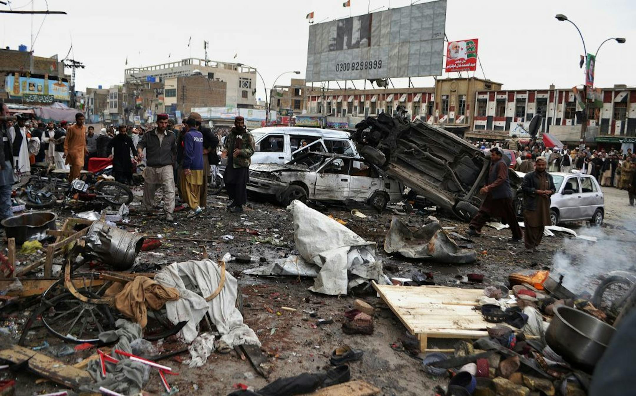 Pakistani police officers and local residents gather at the site of bomb blast in Quetta, Pakistan, Thursday.