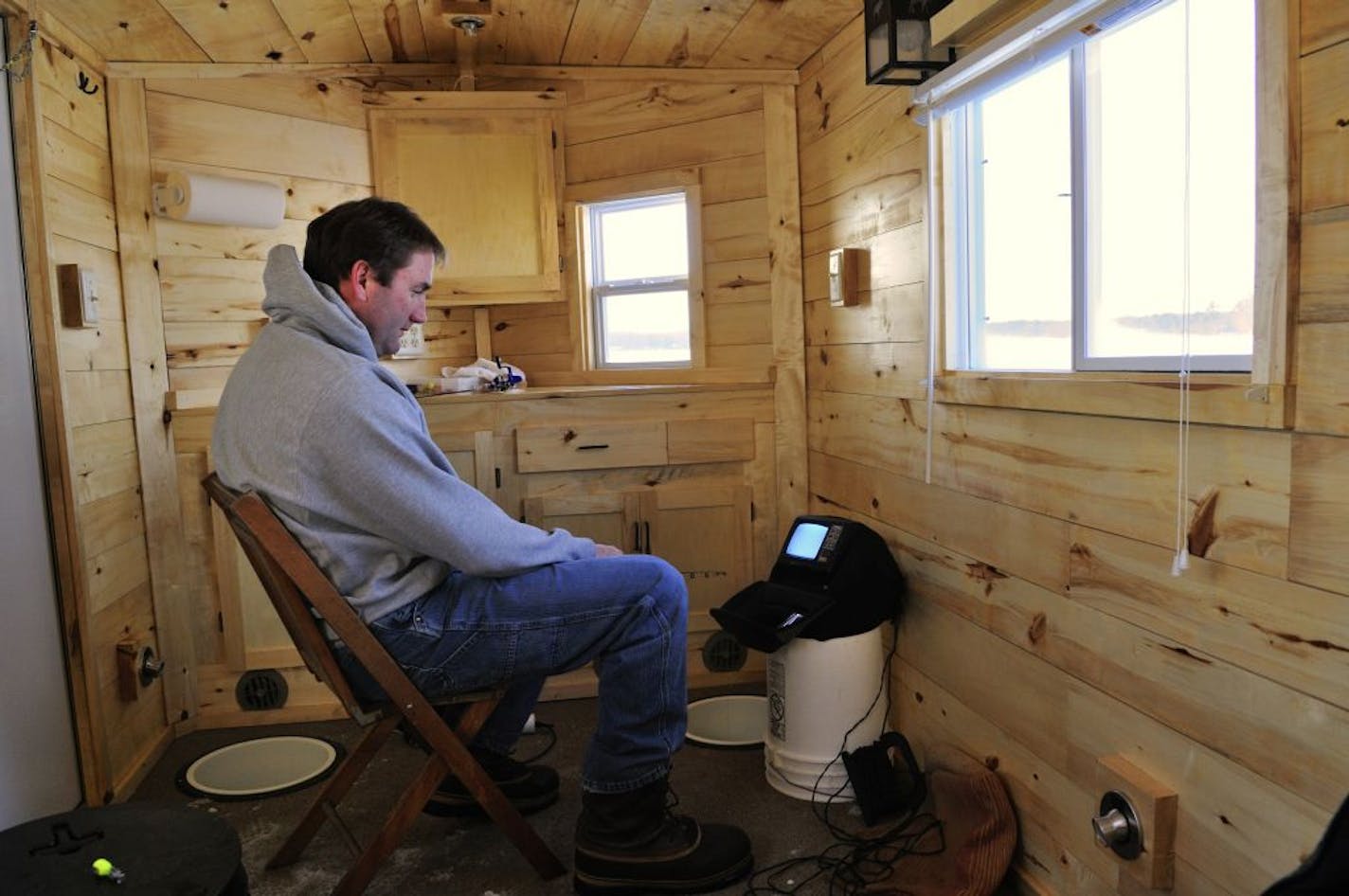 Lindy Frasl, 46, of Brainerd inside the mobile winter fishing house he built. The house is wired for electricity, has thermostaically controlled heat and two sleeping bunks.