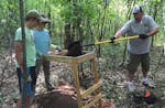 John Petrangelo, Mae Petrangelo and Mike Billadeau sift through a shovelful of dirt in July, looking for artifacts from early peoples who once camped 