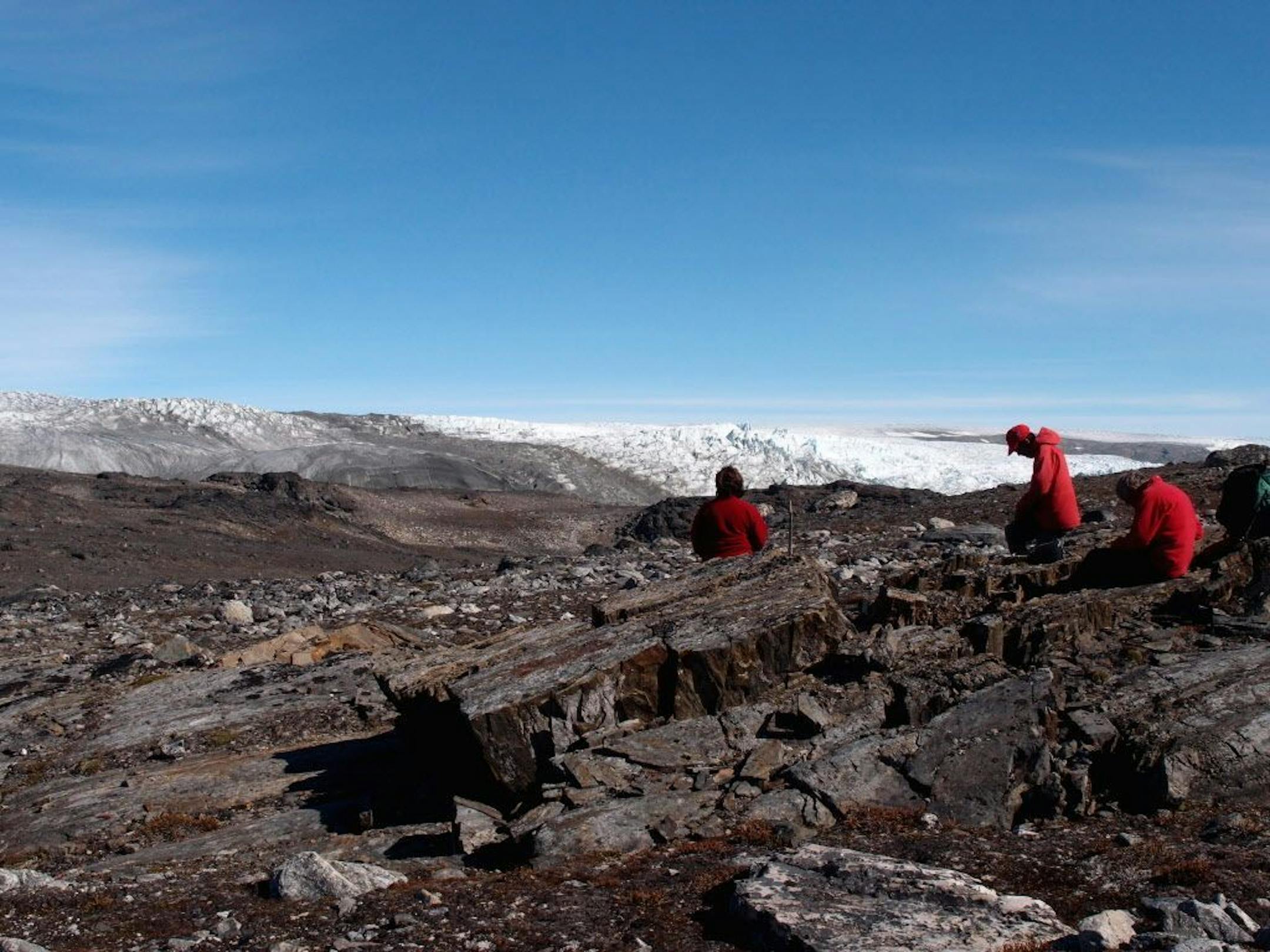 In this photo provided by Laure Gauthiez, taken in July 2012, a field team examine rocks in Greenland. Scientists have found what they think is the oldest fossil on Earth, a remnant of life from 3.7 billion years ago when Earth�s skies were orange and its oceans green. In a newly melted part of Greenland, Australian scientists found the leftover structure from a community of microbes that lived on an ancient seafloor, according to a study in Wednesday, Aug. 31, 2016 journal Nature.