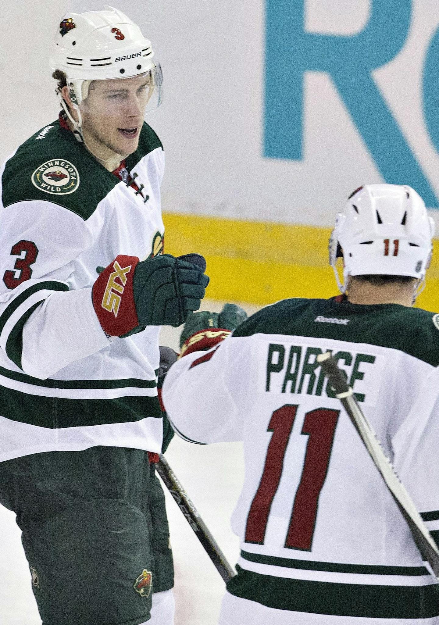 Minnesota Wild's Charlie Coyle (3) and Zach Parise (11) celebrate an empty-net goal against the Edmonton Oilers during the third period of an NHL hockey game Thursday, Feb. 18, 2016, in Edmonton, Alberta. (Jason Franson/The Canadian Press via AP)