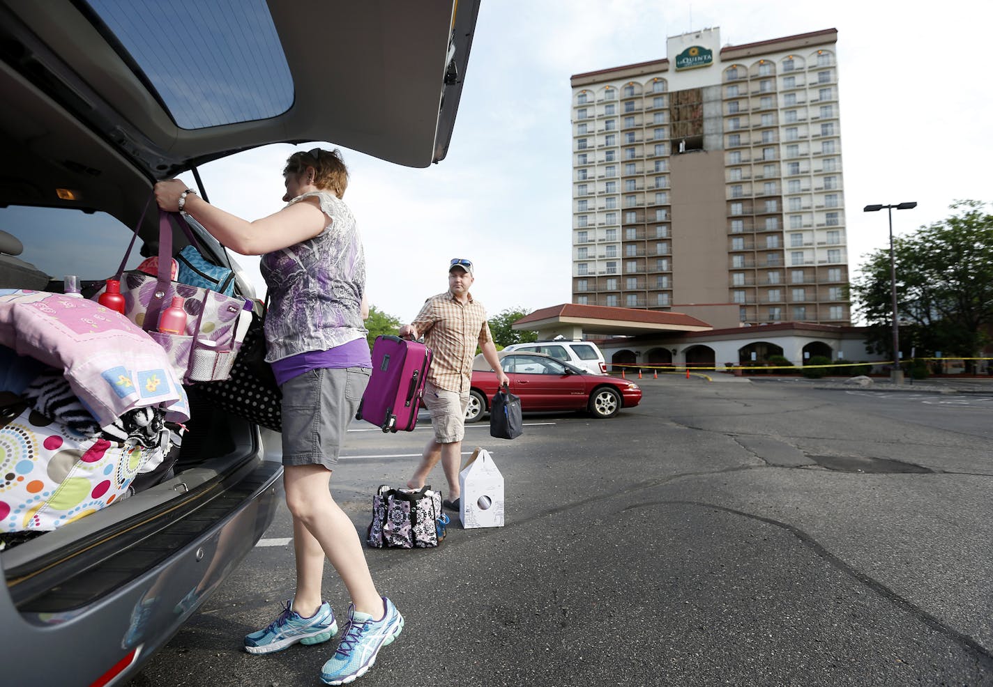 Jay and Linda Schlenker of Bismarck, ND loaded up their car in the parking lot of the La Quinta Inn & Suites in Bloomington. The hotel had its fa&#xc1;ade panels on the 14th-17th floors fall early Monday morning. ] CARLOS GONZALEZ cgonzalez@startribune.com - June 8, 2015, Bloomington, MN, La Quinta Inn & Suites Bloomington