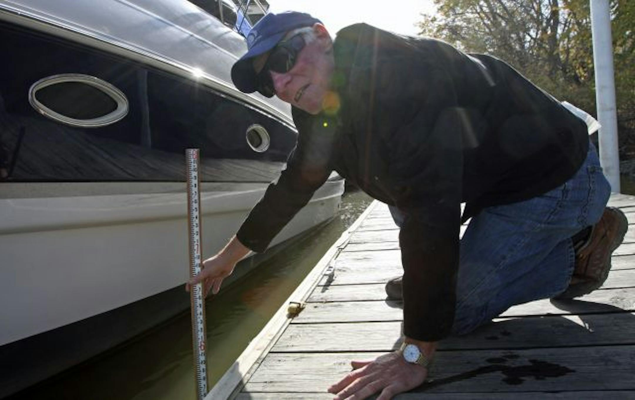 Paul Harms of the River Heights Marina in Inver Grove Heights used a measure to check the water level as boats were being removed from the Mississipi for winter storeage. The marina says a riprap dam used to transport materials from the shore to the old Rock Island Swing Bridge, that is being rebuilt, has restriced the water flow of the Misissippi River causing silt build up, causing water level problems.
