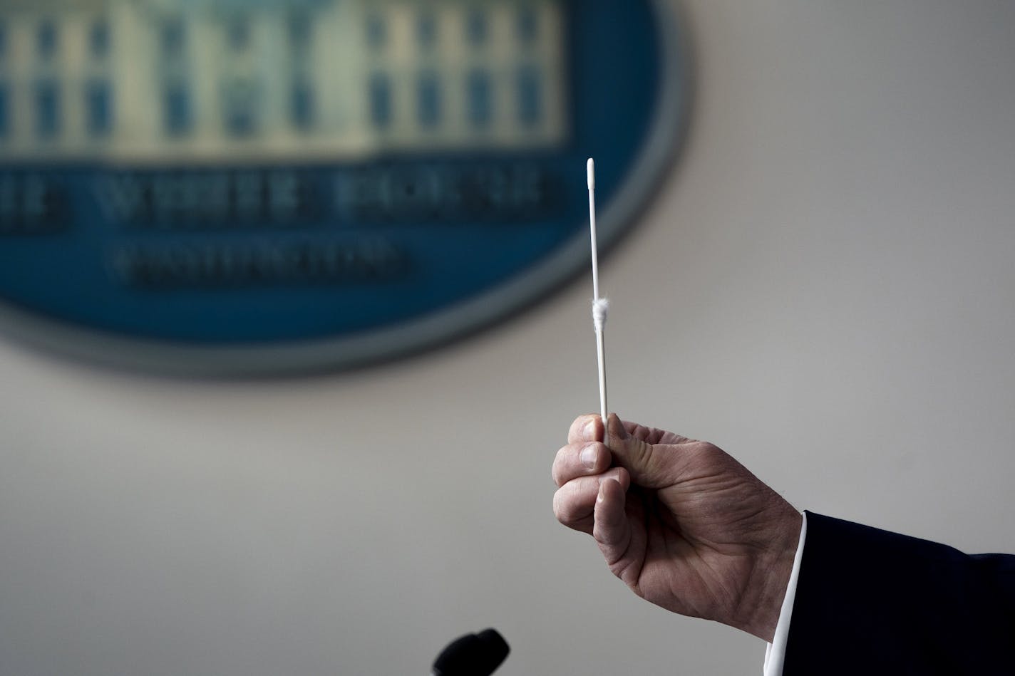 President Donald Trump held up a test swab during a coronavirus briefing at the at the White House in Washington, April 19, 2020. President Trump said Sunday night that the administration was preparing to use the Defense Production Act to compel an unspecified U.S. facility to increase production of test swabs by over 20 million per month. (Anna Moneymaker/The New York Times)