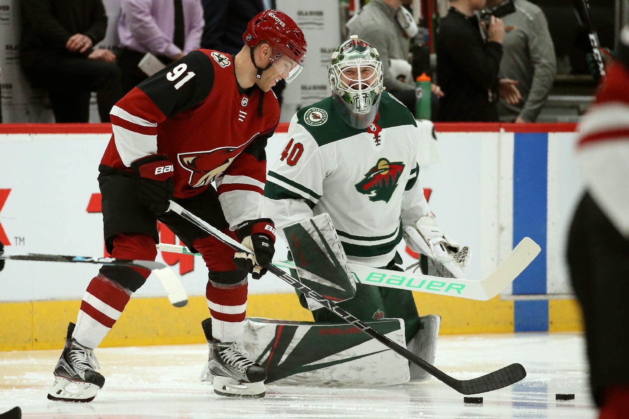 Arizona Coyotes left wing Taylor Hall (91) talks with Minnesota Wild goaltender Devan Dubnyk (40) prior to an NHL hockey game Thursday, Dec. 19, 2019, in Glendale, Ariz. Hall was acquired by the Coyotes in a trade with the New Jersey Devils. (AP Photo/Ross D. Franklin)