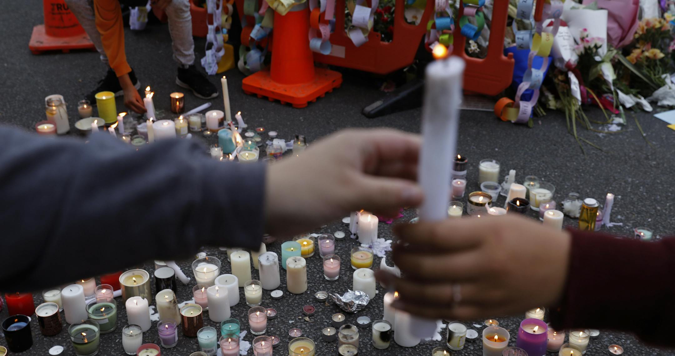 Students light candles as they gather for a vigil to commemorate victims of Friday's shooting, outside the Al Noor mosque in Christchurch, New Zealand, Monday, March 18, 2019. Three days after Friday's attack, New Zealand's deadliest shooting in modern history, relatives were anxiously waiting for word on when they can bury their loved ones.(AP Photo/Vincent Yu)