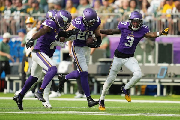 Vikings safety Harrison Smith (22) celebrated with teammates after intercepting Packers quarterback Aaron Rodgers near the end of the first half at U.