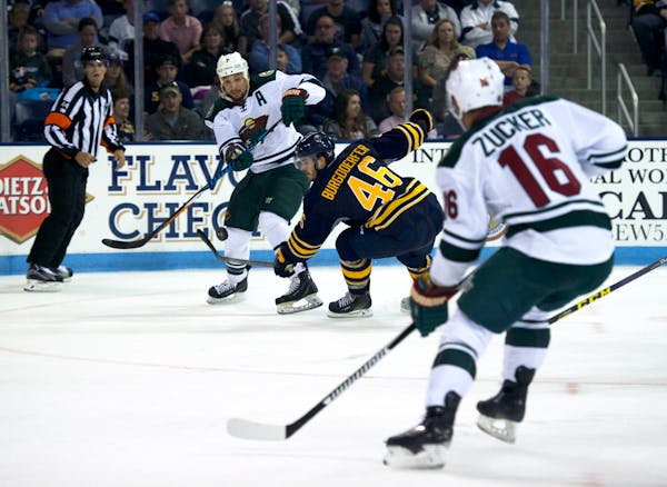 The Wild's Chris Stewart passed to Jason Zucker as the Sabres' Erik Burgdoerfer defended during an NHL exhibition game Monday in State College, Pa. Zu