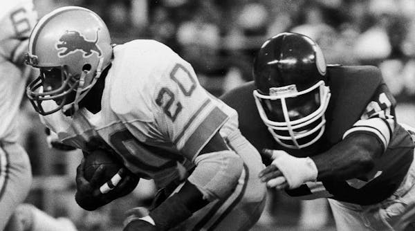 Running back Billy Sims (20) of the Detroit Lions runs out of the grasp of Greg Smith of the Minnesota Vikings in the first half of play in Minneapoli