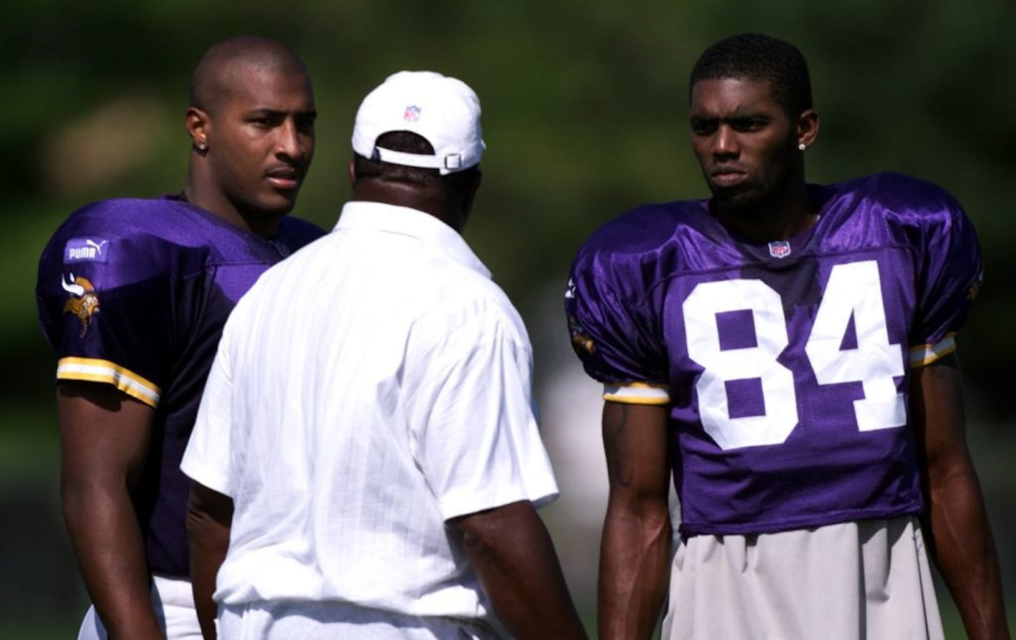 Minnesota Vikings quarterback Daunte Culpepper, #11 and wide receiver Randy Moss, #84 talk with head coach Dennis Green in 2006.