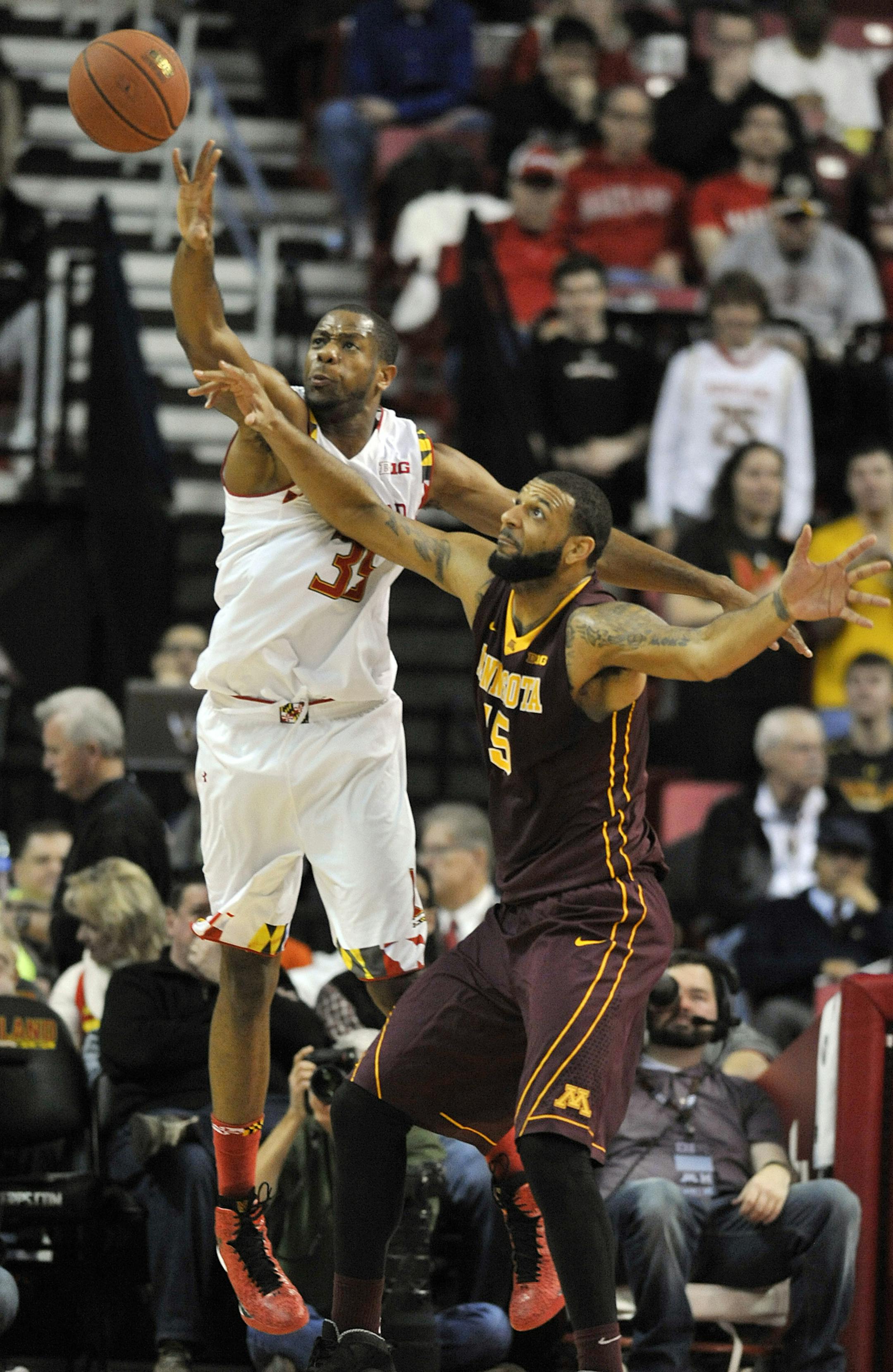 Maryland forward Damonte Dodd, left, blocks a pass to Minnesota forward Maurice Walker during the first half of an NCAA college basketball game Saturday, Jan. 3, 2015 in College Park, Md. Maryland won 70-58. (AP Photo/Gail Burton)