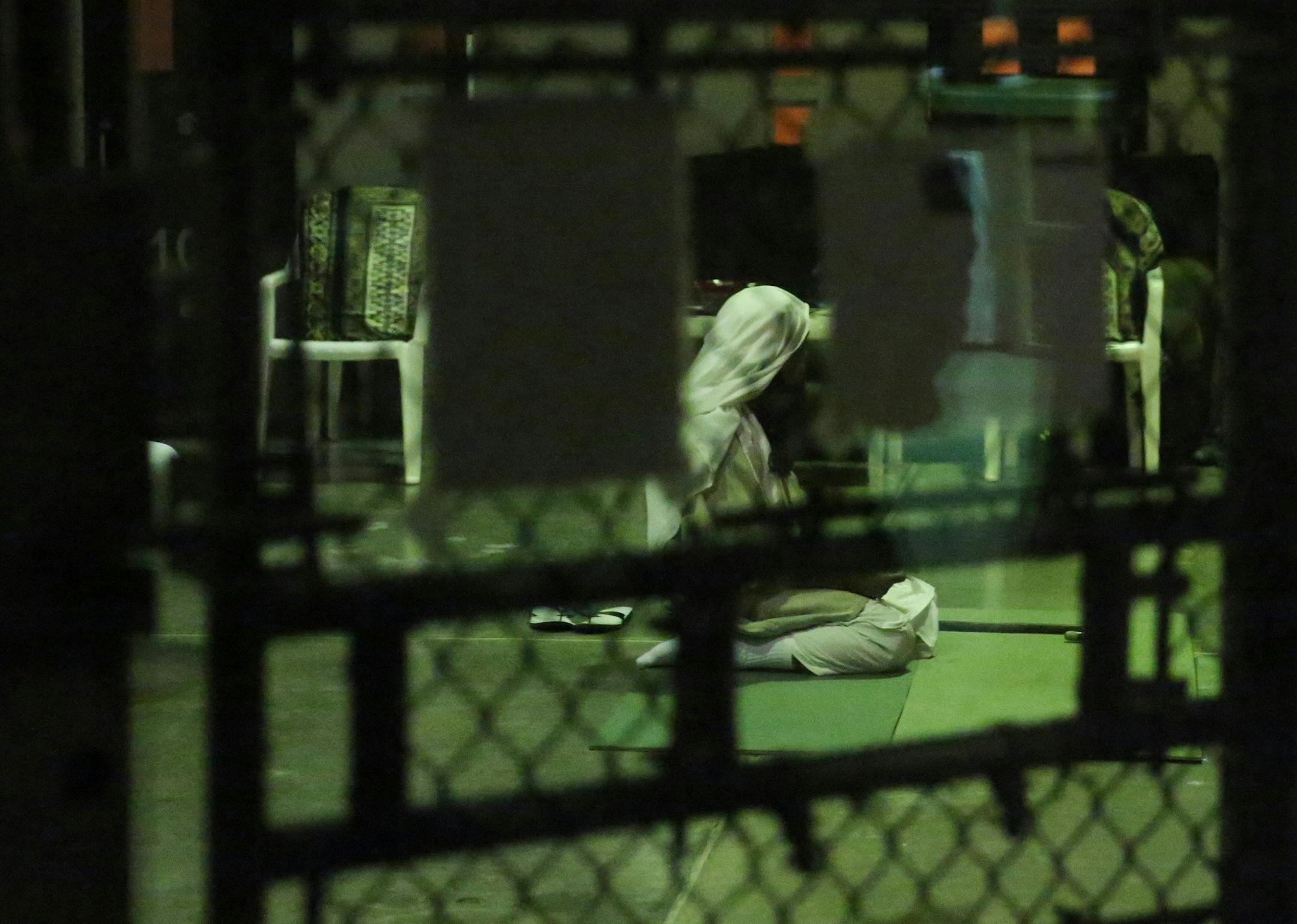 A detainee kneels in prayer at sunset on February 11, 2017, at Camp Six at Guantanamo's Detention Center Zone. The military approved release of this photo. (Emily Michot/Miami Herald/TNS) ORG XMIT: 1200281
