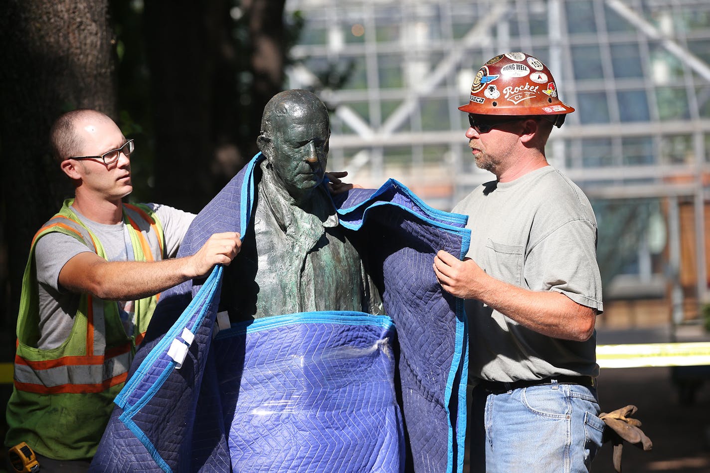 Derek Rydberg, left, and Jason Reis wrapped the sculpture "Walking Man," by George Segal, to move it from its location to storage at the Minneapolis Sculpture Garden on Wednesday.