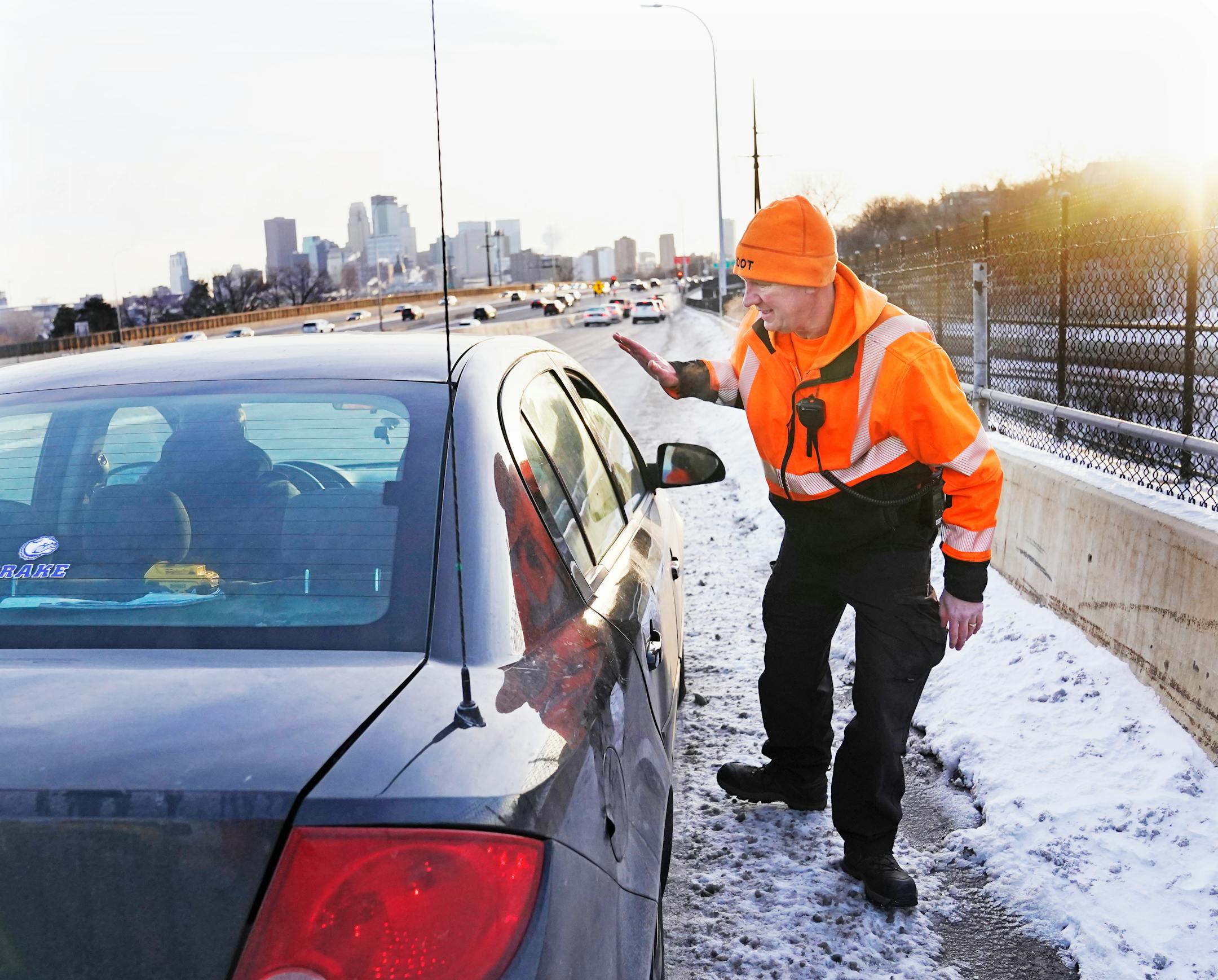 Mike Ahlman, MnDOT's Freeway Incident Response Safety Team driver, waves to a motorist who was pulled over and parked on a ramp off of I-394 in a dangerous spot.
