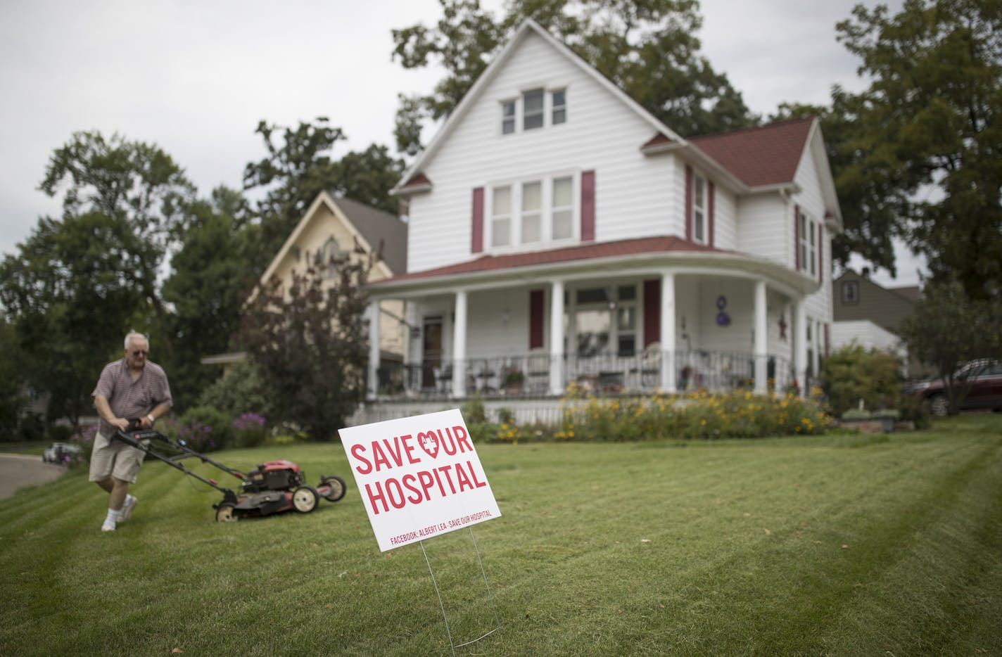 Wayne Thorson mowed his lawn, that has a "Save Our Hospital" sign in the front yard Thursday August 24,2017 in Albert Lea, MN. The Mayo Clinic's plan to remove key inpatient and obstetrics services from its hospital in Albert Lea has caused uproar. Thorson&#xed;s wife was a nurse at the hospital and has recently retired.] JERRY HOLT &#xef; jerry.holt@startribune.com