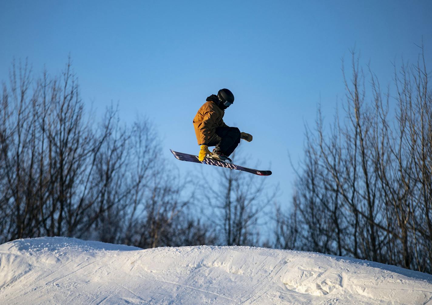 A snowboarder caught some air off a small ski jump in the Spirit Mountain terrain park.