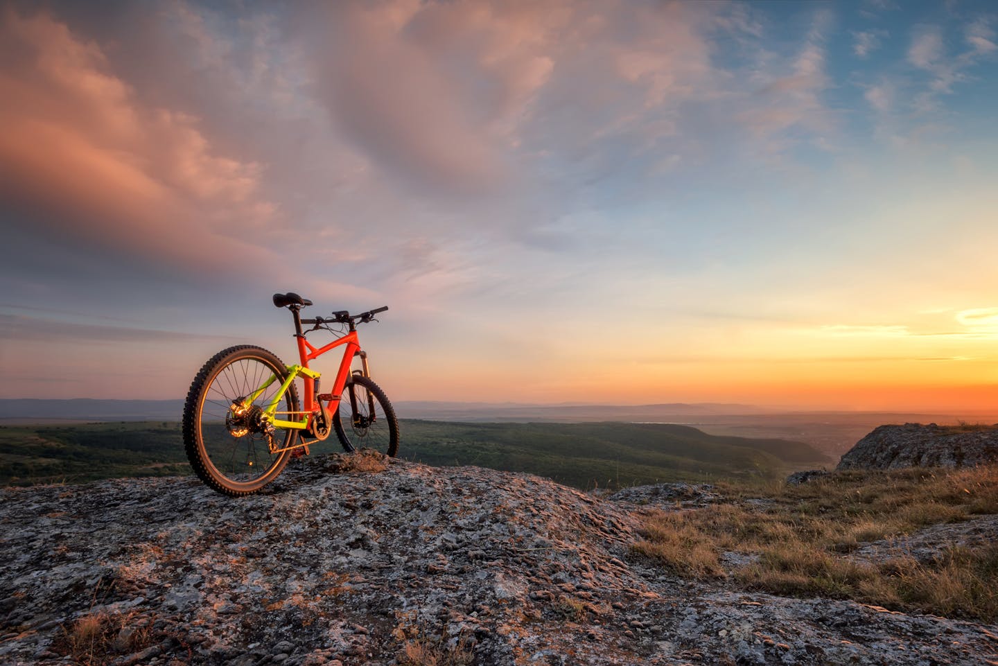 Beautiful sunset view with a mountain bike at the top of a hill