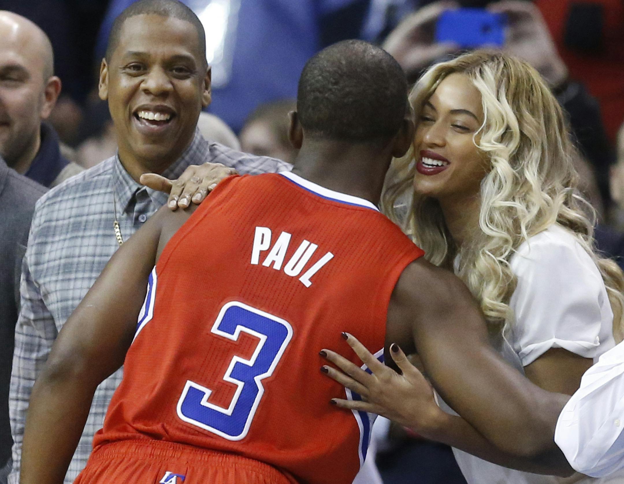 Los Angeles Clippers guard Chris Paul (3) greets Jay-Z, left, and Beyonce, right, before the start of an NBA basketball game against the Oklahoma City Thunder in Oklahoma City, Thursday, Nov. 21, 2013. (AP Photo/Sue Ogrocki)