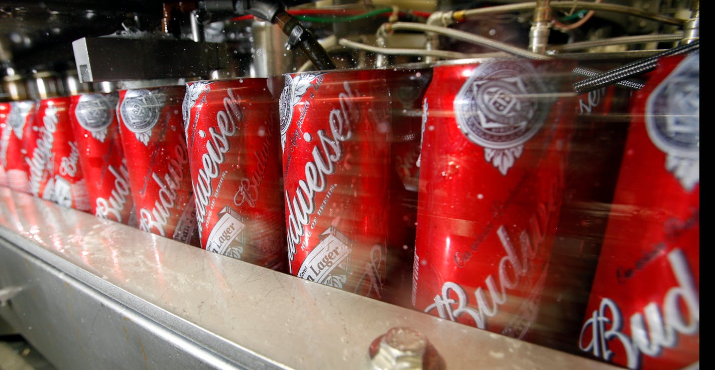 FILE - In this Wednesday, March 2, 2011, file photo, Budweiser cans run through a filling machine at the Anheuser-Busch brewery in the Van Nuys area of Los Angeles. After several years of losing ground to smaller craft brewers, Anheuser-Busch, the country's biggest brewery is aiming its marketing at its core consumers, the folks who likely wouldn�t reach for a craft beer in any case. And they�re doing it with a playful wink and nod that says, �We didn�t want their fancy-schmancy beer anyway.� (A