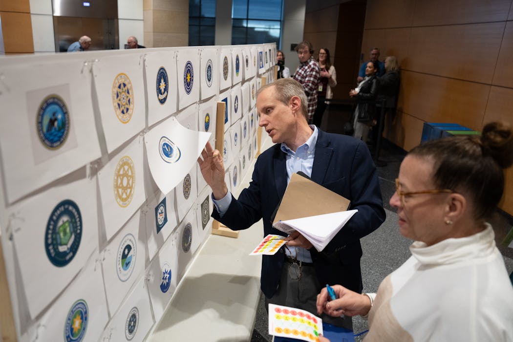 Secretary of State Steve Simon checked the votes on the back of state seal designs.
