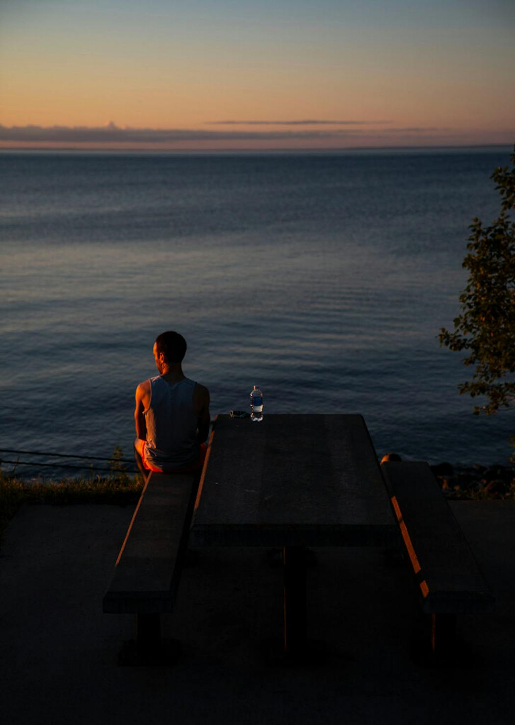 A runner watches the sun rise over Lake Superior before the Garry Bjorklund Half Marathon in 2021.