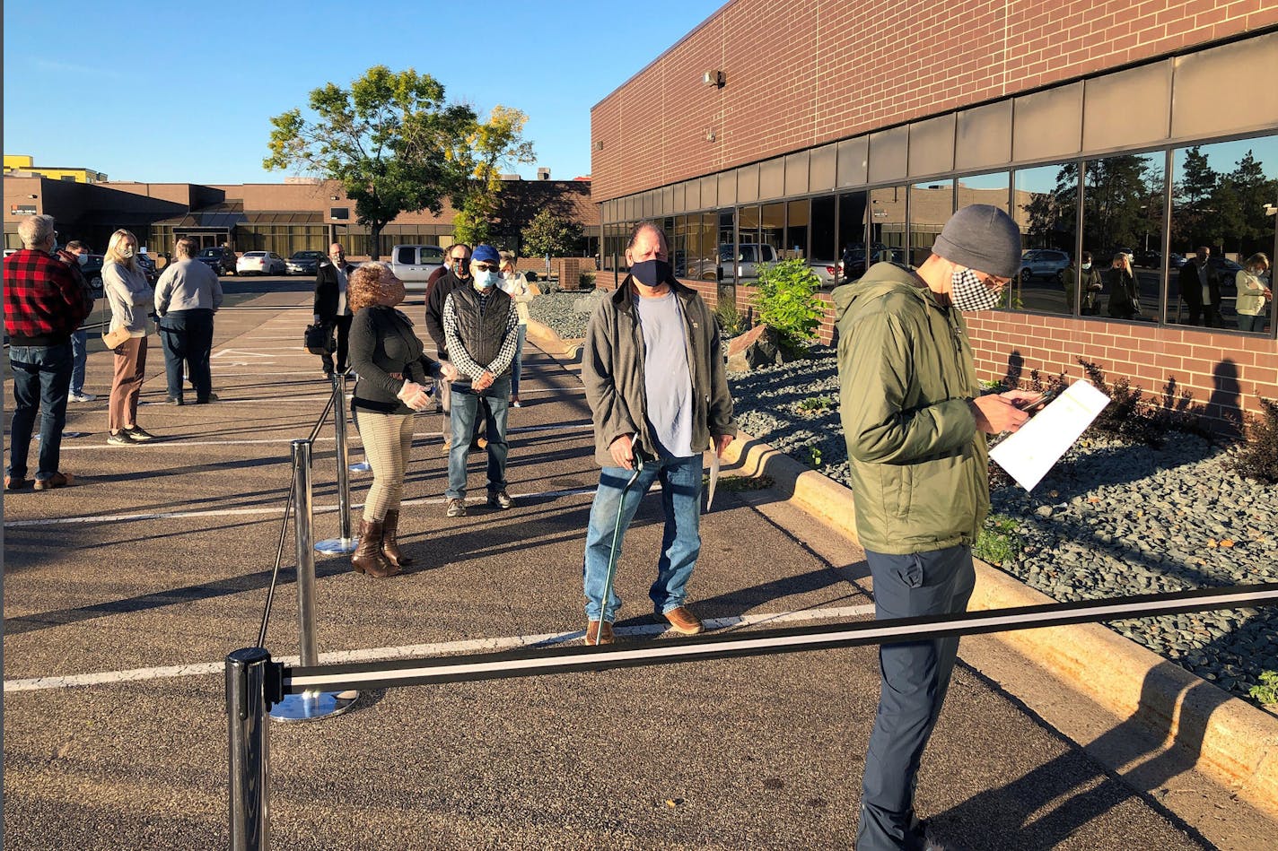 FILE - In this Sept. 8, 2020 file photo voters line up outside of the Minneapolis early voting center as Minnesota opened early voting for the general election. Like political contests around the country, Minnesota's general election is expected to be like none other. The COVID-19 pandemic has prompted a record number of Minnesota's eligible voters to seek absentee ballots, and early voting has been taking place at a breakneck pace. (AP Photo/Steve Karnowski, File)