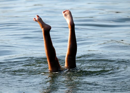 Legs sticking up in a hand stand in Buffalo Lake.