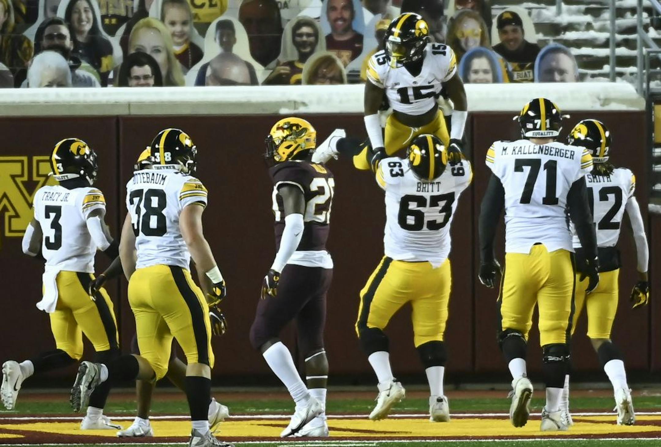Iowa Hawkeyes offensive lineman Justin Britt (63) lifted running back Tyler Goodson (15) into the air after Goodson's second quarter rushing touchdown against Minnesota.