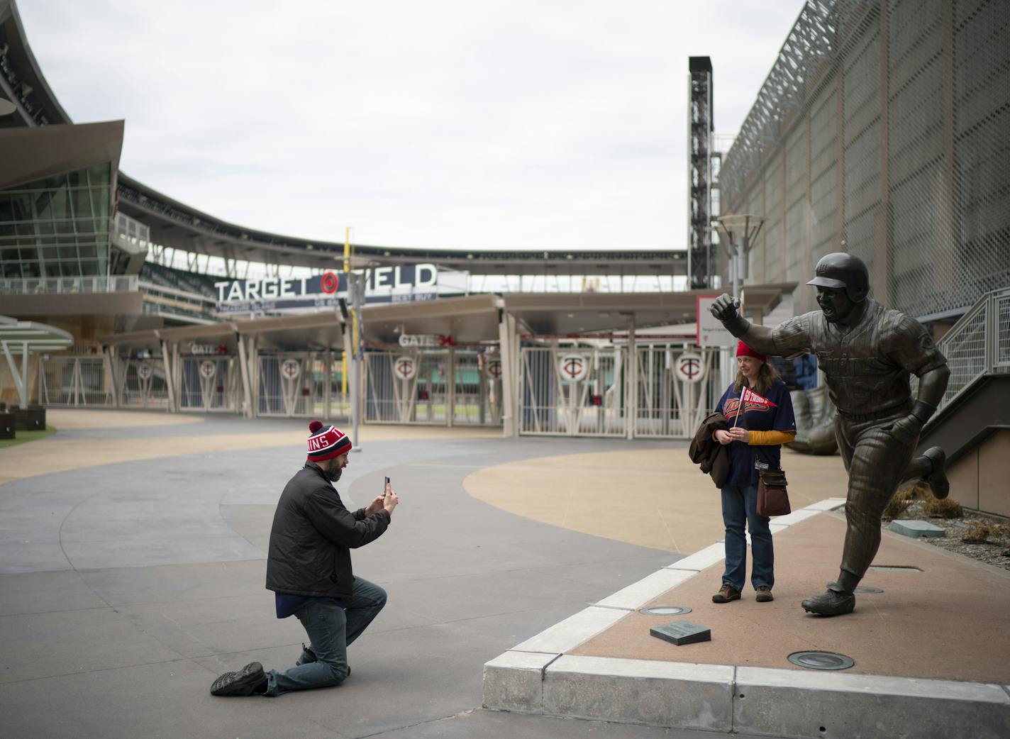 Michele Schluender posed next to the statue of Kirby Puckett before being photographed by her husband, Joe, on the plaza outside Target Field at a time when it should have been busy with fans arriving for the home opener.