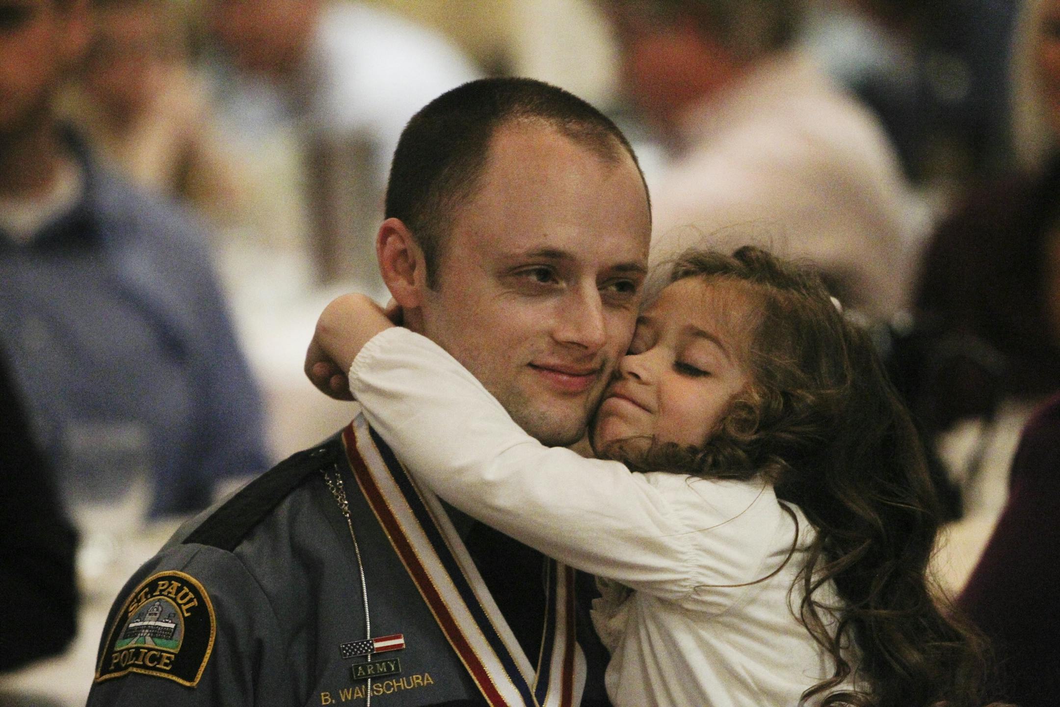 St. Paul police officer Brian M. Wanschura, who was shot by a suspect while on patrol on Oct. 23, 2012, gets a hug from his daughter, Ella, 5,