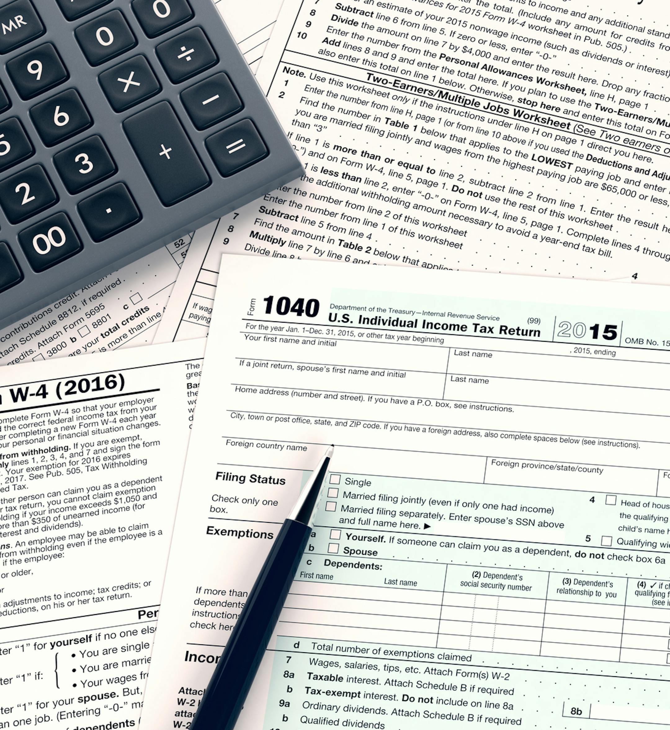 top view of forms for usa taxes with a pen and an electronic calculator, empty spaces for custom text at the right (3d render). istock
