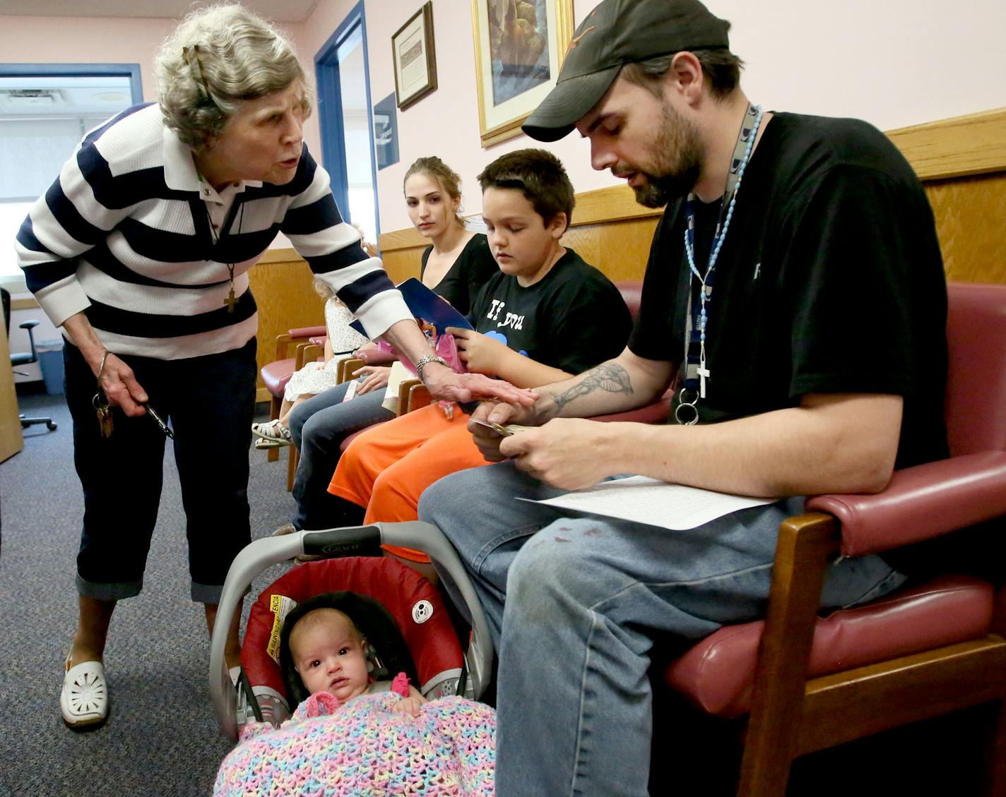 Here, Mary Jo Copeland pffers comfort to Cody Lease, who had just confided that it had been 17 years to the day that he witnessed his mother commit suicide in front of him after the Lease family came to Copeland at her original facility, Sharing and Caring Hands Thursday, July 16, 2015, in Minneapolis, MN. They had been camping when they found one of Copeland's crosses and decided to seek her help. Cody Lease had lost his job as a welder, causing the family of five to become homeless.](DAVID JOL