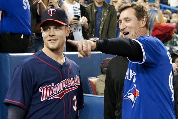The Twins intend to shut down Justin Morneau (left, with hockey great Wayne Gretzky) for the final series of the season.