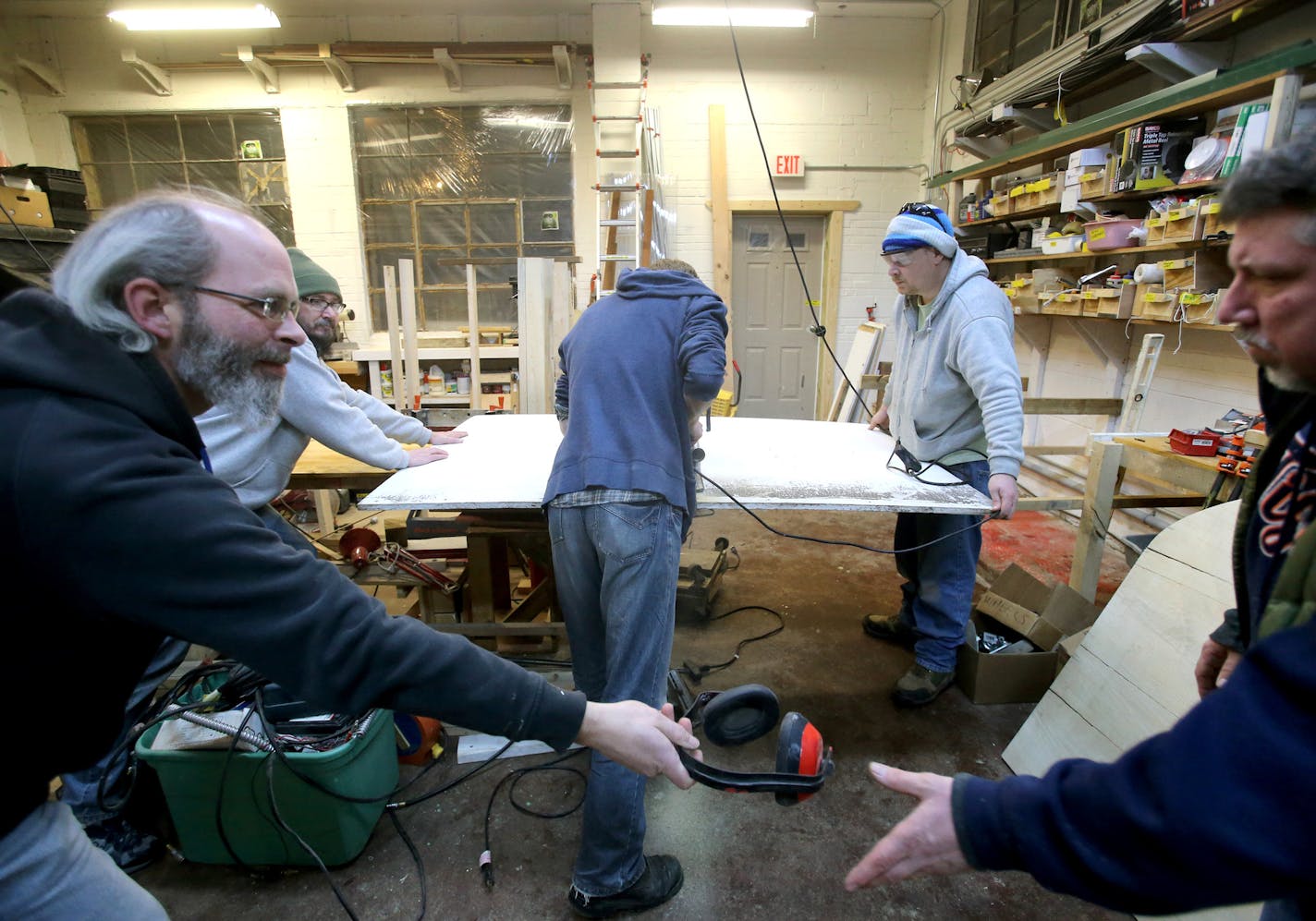 Four formerly homeless people, including a couple, have settled into a cluster of tiny houses they helped build in Madison along with members of Occupy Madison. Here, village resident, also known as a steward, Gene Cox, 41, left, hands ear protection head phones to Bruce Wallbaum, OM treasurer, as other volunteers and steward Russell Albers, 35, rear right, work on a shop project Tuesday, March 3, 2015, in Madison, WI.](DAVID JOLES/STARTRIBUNE)djoles@startribune.com Three men and a woman who onc