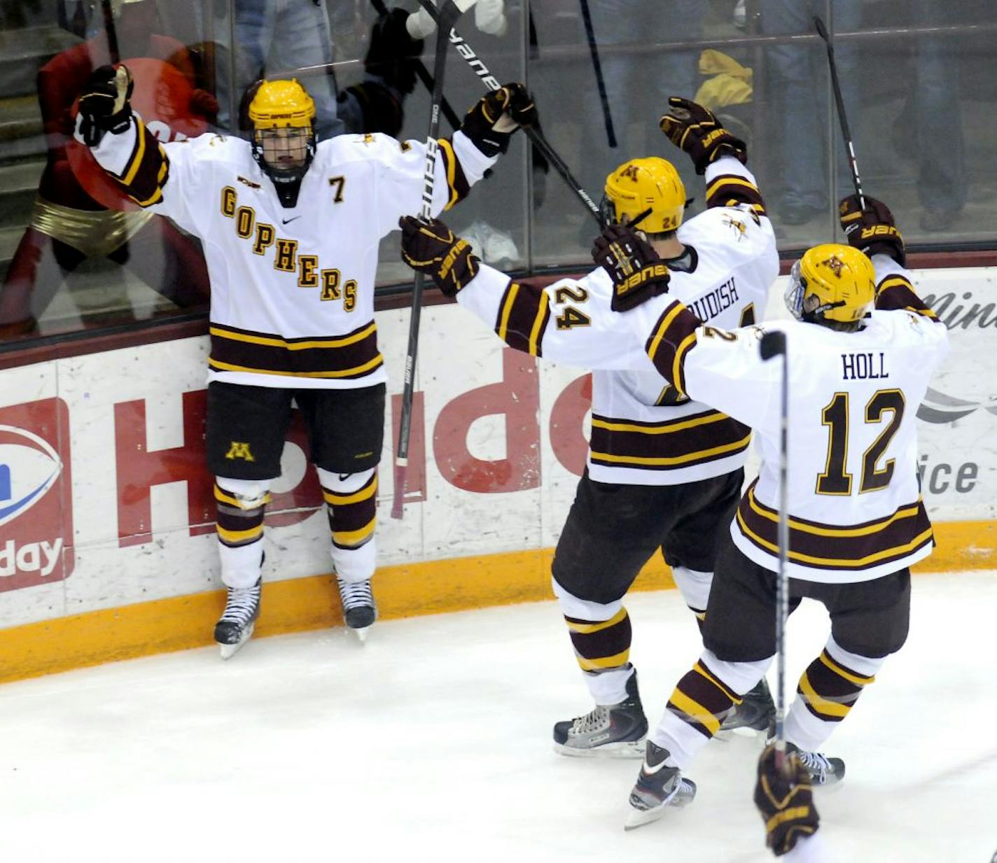 Gophers freshman forward Kyle Rau (left) waited to embrace teammates Zack Budish and Justin Holl after scoring the decisive goal against North Dakota on Saturday night at Mariucci Arena.