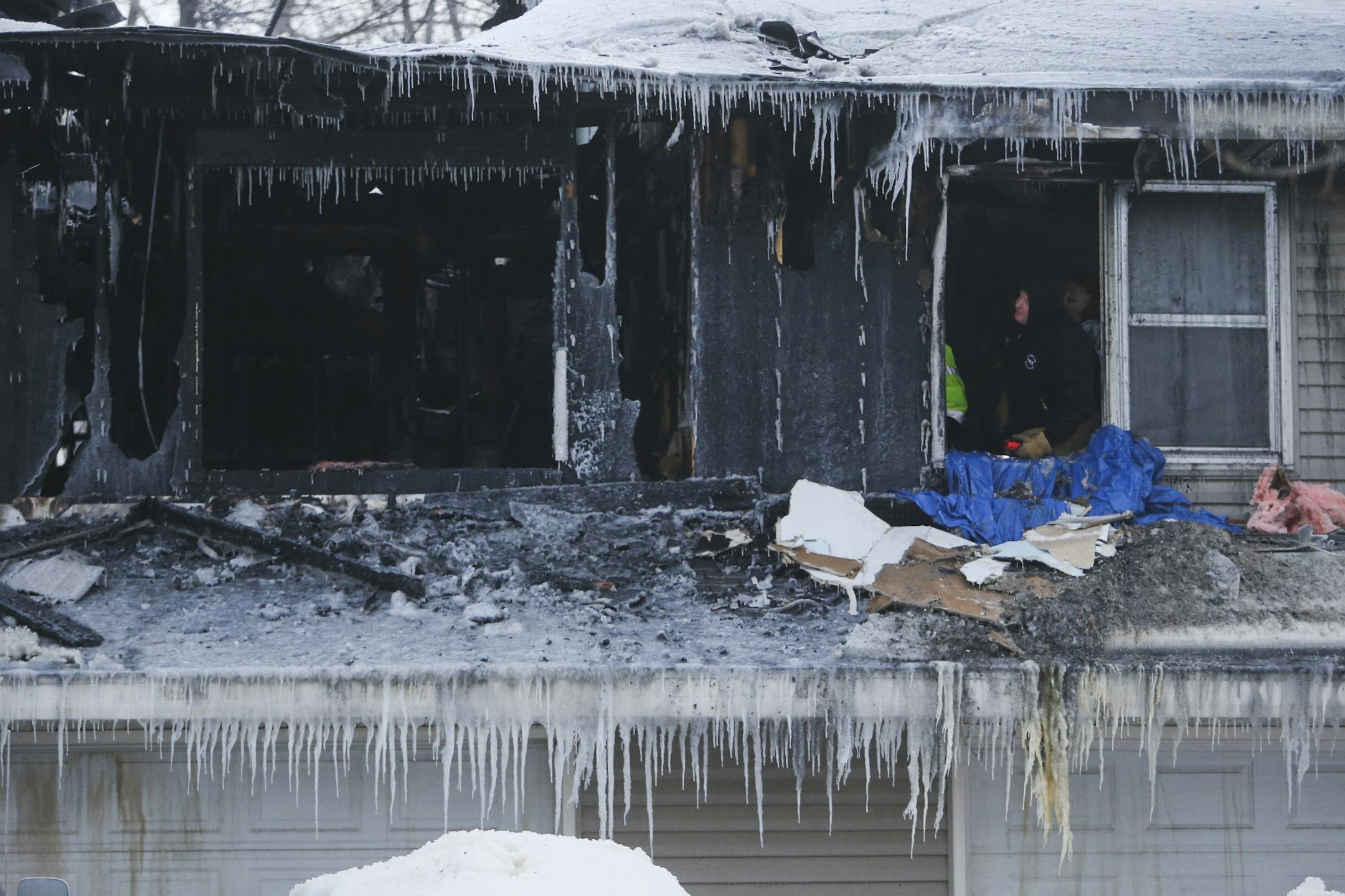 Fire investigators at a home on the 7200 block of W. River Road, the site of fire that heavily damaged the home on Wednesday, Feb. 5, 2014, in Brooklyn Center.