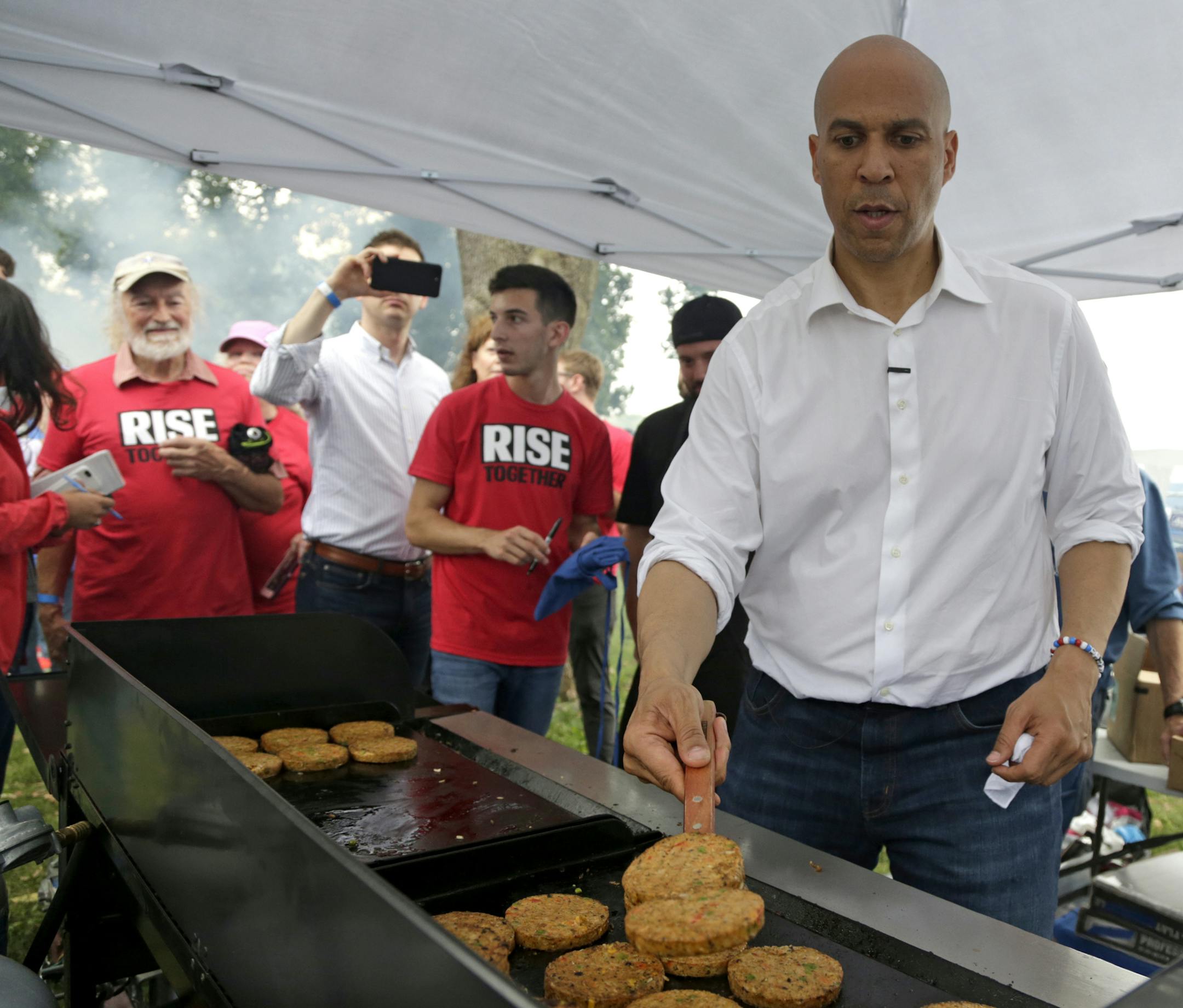 Democratic presidential candidate Sen. Cory Booker, D-N.J. flips veggie burgers at the Polk County Democrats Steak Fry, in Des Moines, Iowa, Saturday, Sept. 21, 2019. (AP Photo/Nati Harnik)