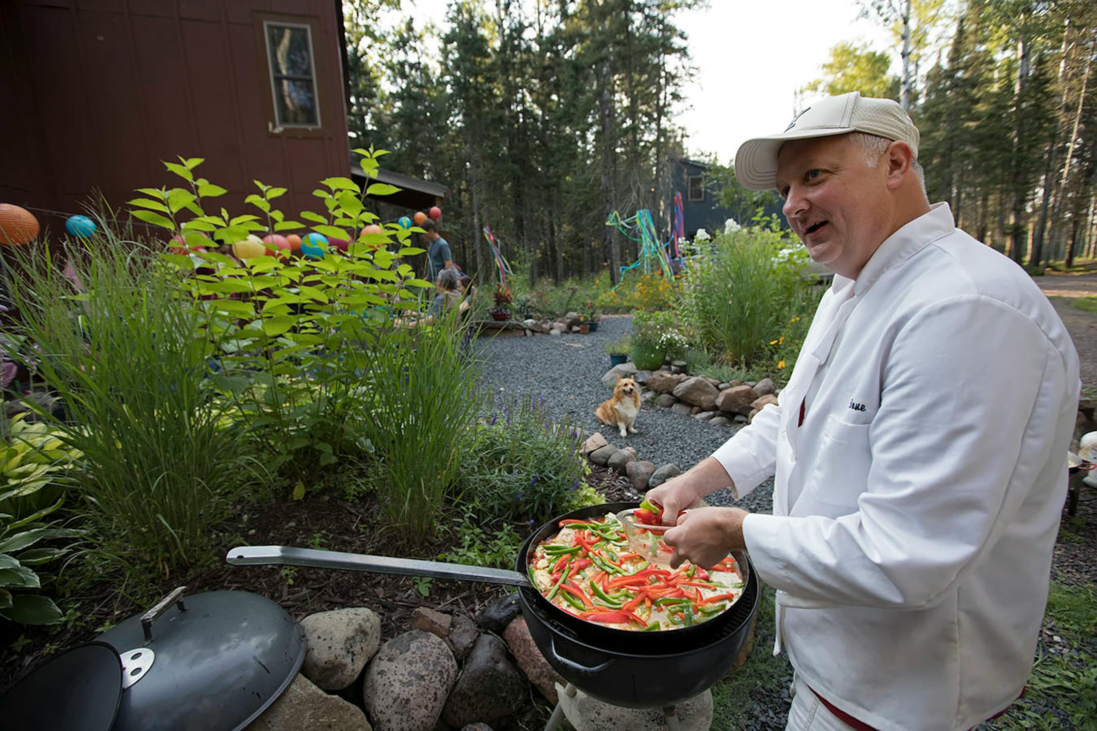 Tom Anderson prepares the paella for their guests at Knife RIver cabin.