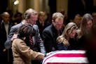 Neil Bush, second from left, and his wife Maria, left, and members of their family pay their respects at the flag-draped casket of former President Ge