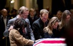 Neil Bush, second from left, and his wife Maria, left, and members of their family pay their respects at the flag-draped casket of former President Ge