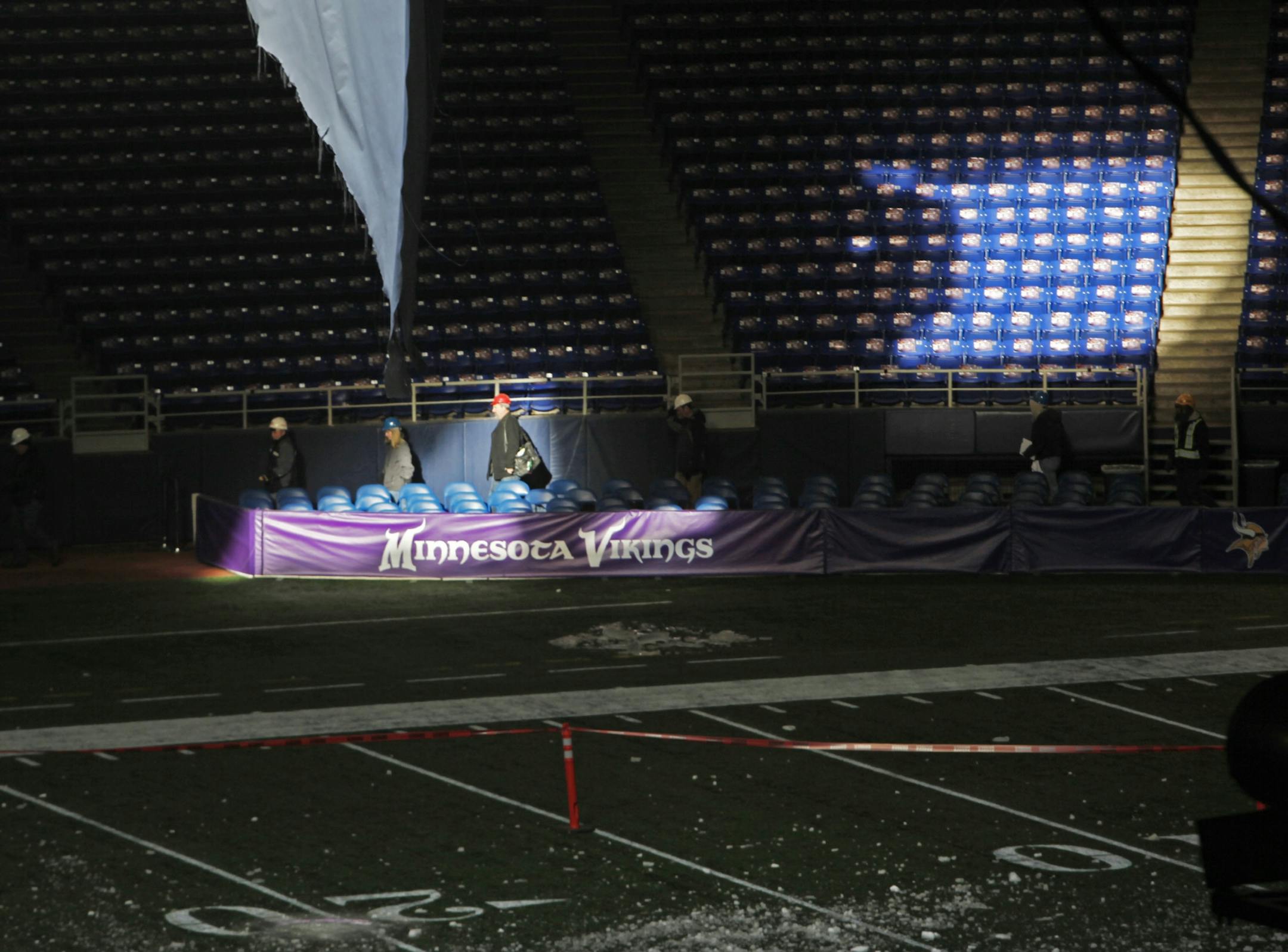Workers head onto the field for the day as the assessment for the roof repair begins at the Metrodome.