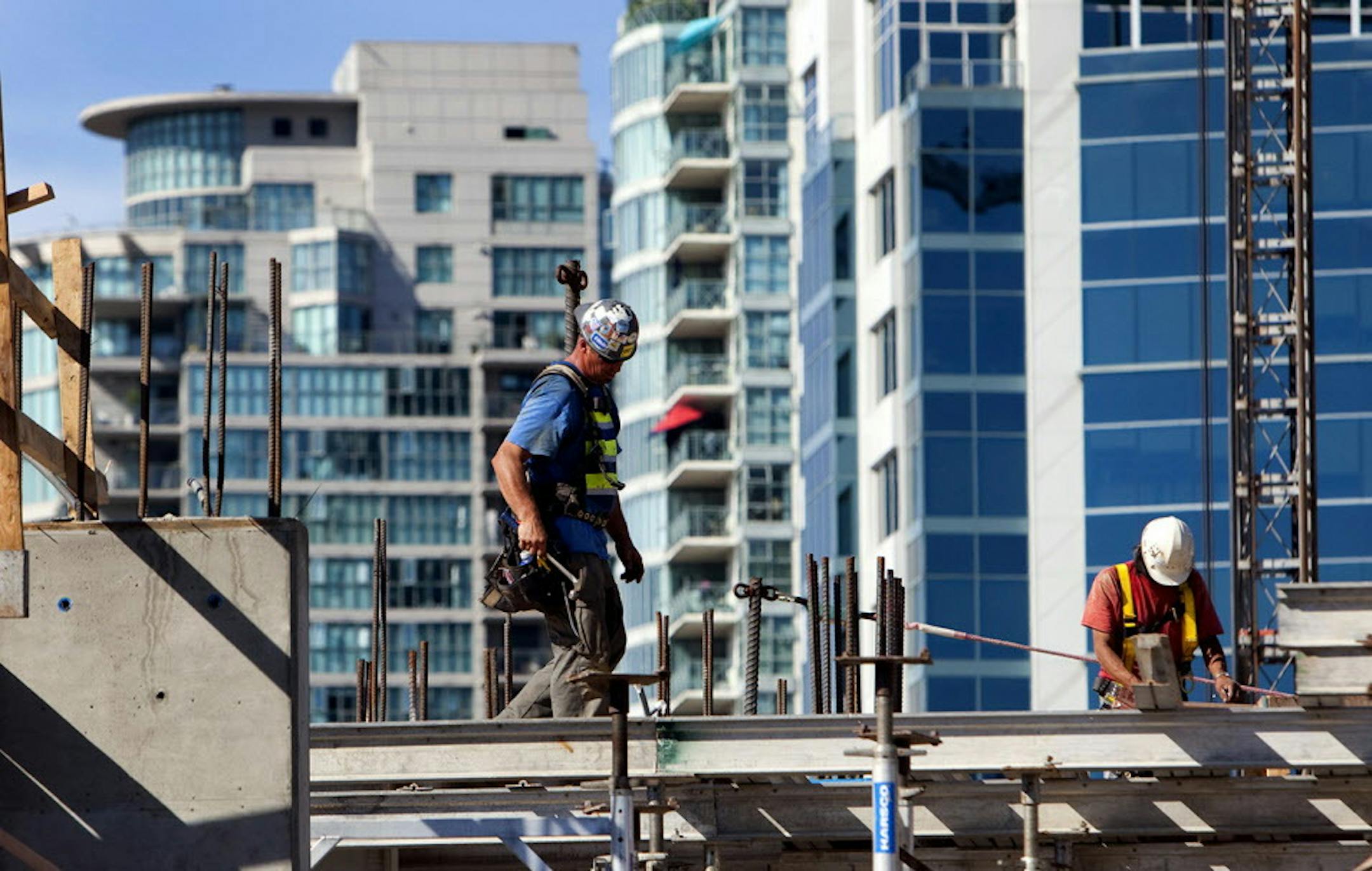 Contractors work a condominium under construction in downtown Vancouver, British Columbia, Canada, on Wednesday, Aug. 7, 2013. The Canada Mortgage and Housing Corp. is scheduled to release housing starts figures on Aug. 9. Photographer: Ben Nelms/Bloomberg ORG XMIT: 176014330