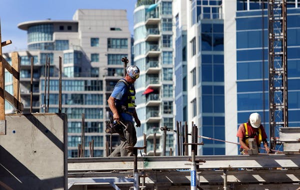 Contractors work a condominium under construction in downtown Vancouver, British Columbia, Canada, on Wednesday, Aug. 7, 2013. The Canada Mortgage and