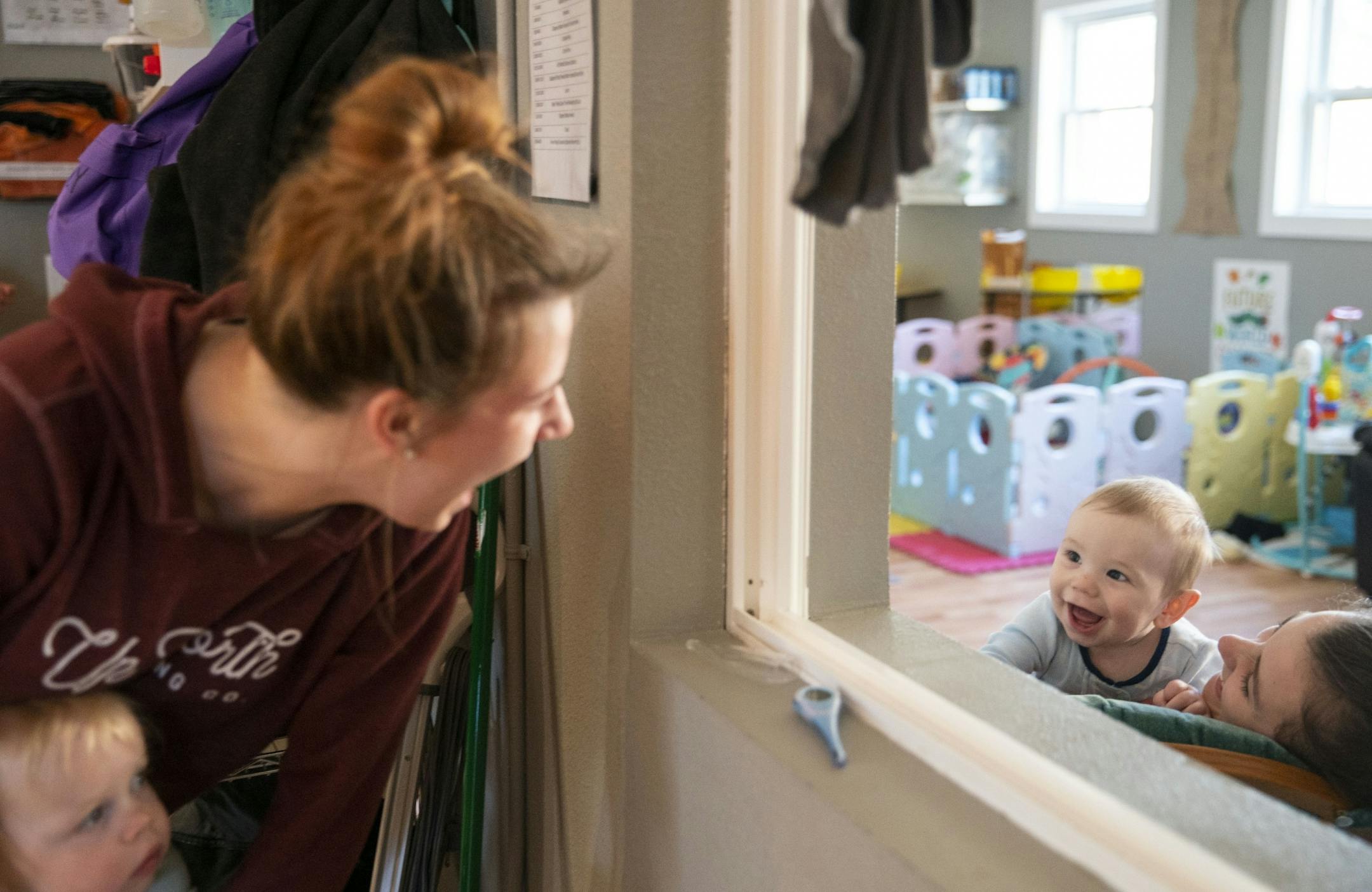 (Left) Morgan Birdman made faces at 8-month-old Beckham laugh during snack time at Aunty's Child Care in Duluth, MN on Thursday.
