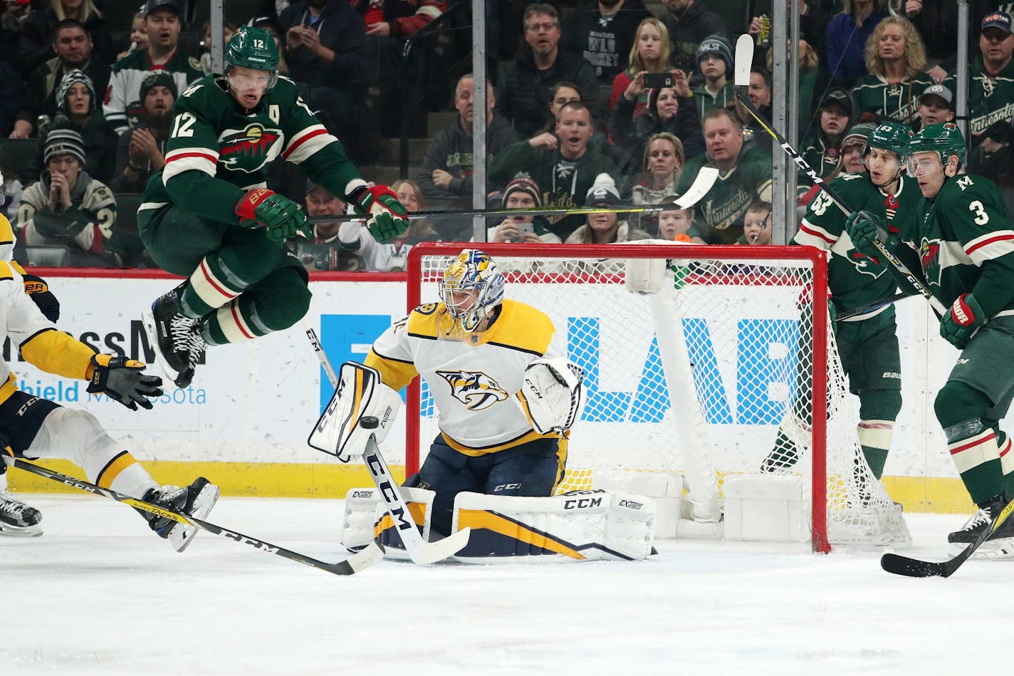 Minnesota Wild center Eric Staal (12) leapt over a shot on goal as Nashville Predators goaltender Pekka Rinne