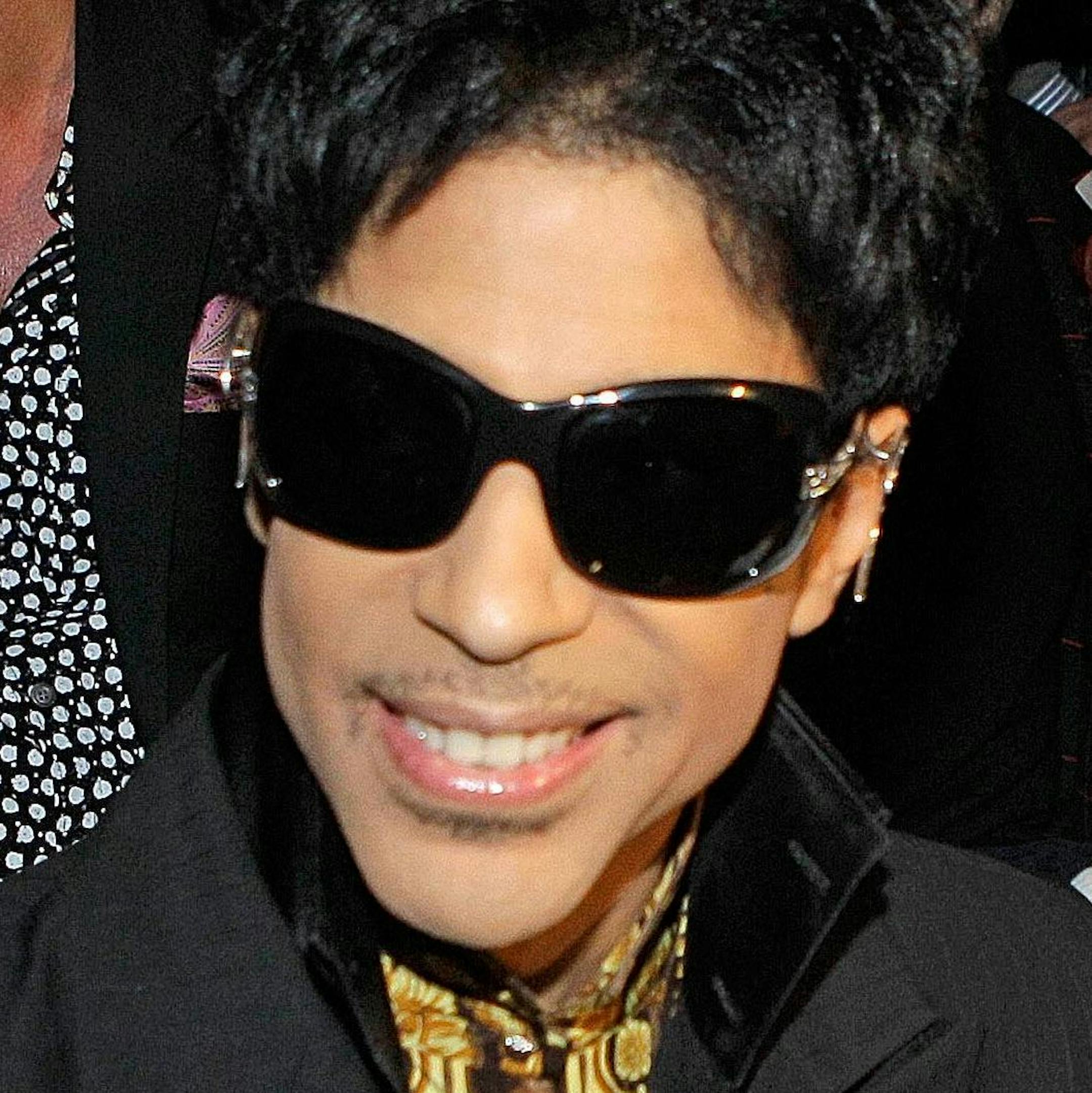 Singer Prince and his date are shown seated before the start of the Versace for H&M fashion show in New York, Tuesday, Nov. 8, 2011. (AP Photo/Kathy Willens) ORG XMIT: MIN2013040117084859