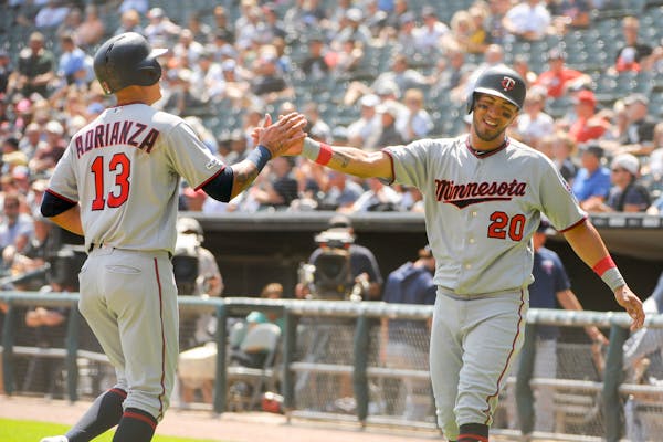 Ehire Adrianza (13) and Eddie Rosario (20) celebrate a two-run RBI single by C.J. Cron during the first inning