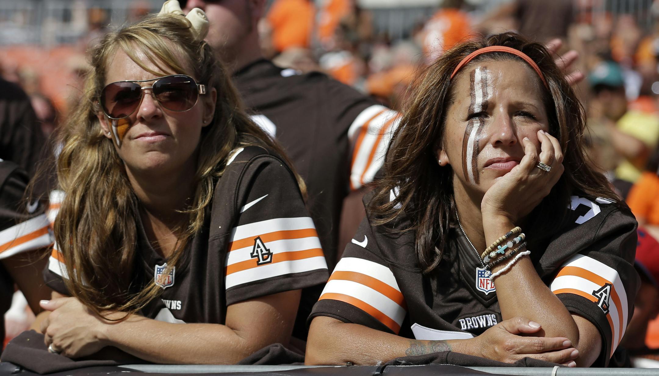 Two Cleveland Browns fans look on glumly near the end of a 23-10 loss to the Miami Dolphins in an NFL football game Sunday, Sept. 8, 2013, in Cleveland. (AP Photo/Tony Dejak) ORG XMIT: MIN2013091920020792