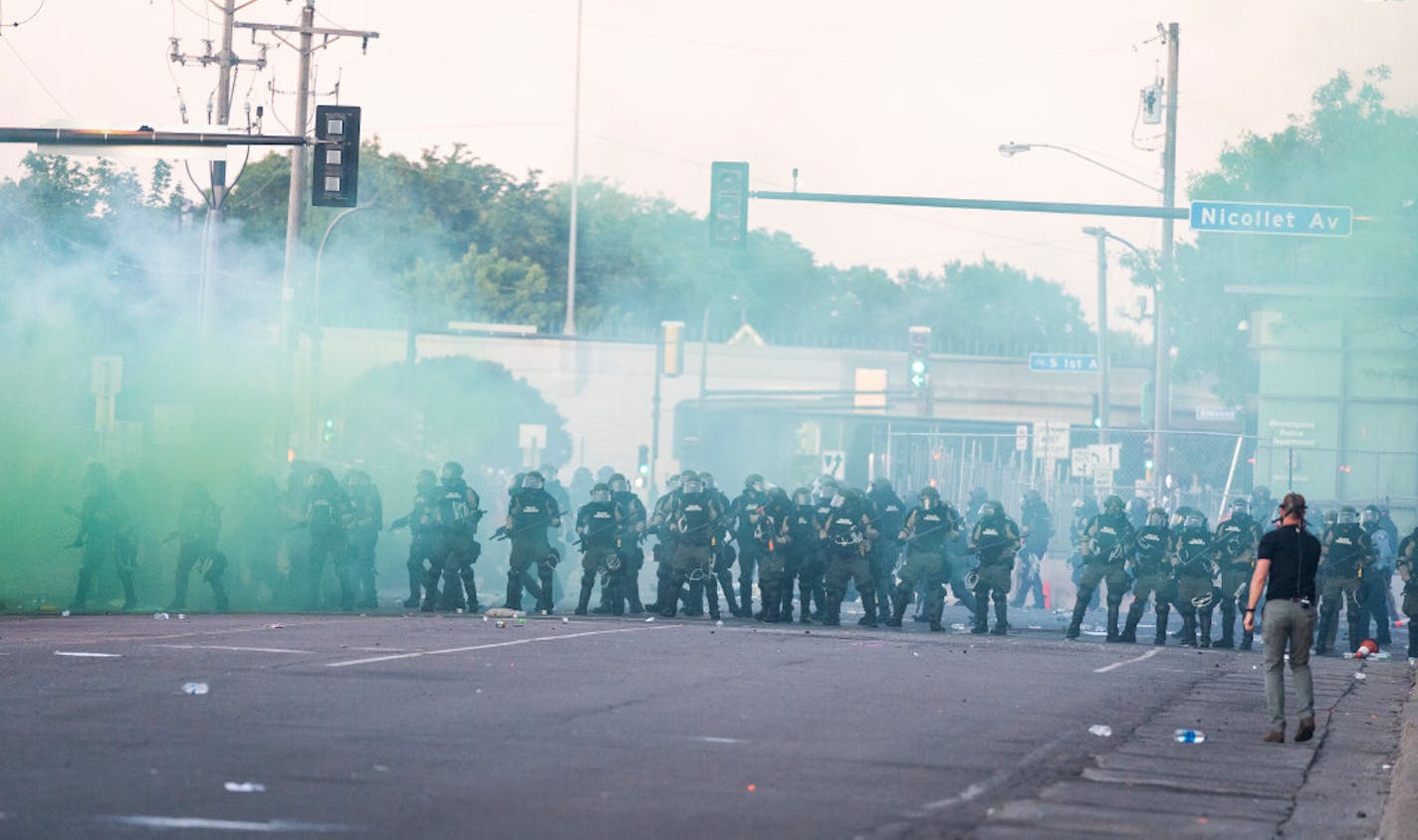 A police presence using tear gas moved in near the Fifth Precinct police station on Saturday night in Minneapolis.